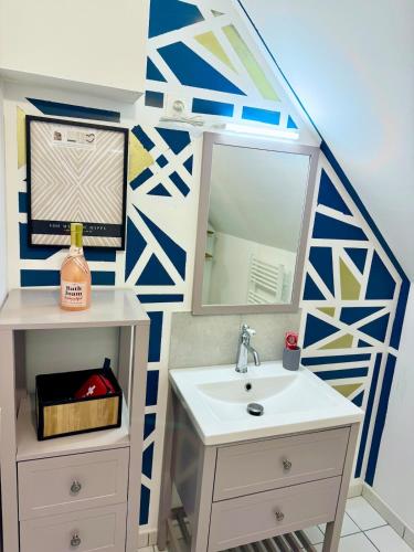 une salle de bain avec un lavabo et un miroir dans l'établissement L'escale du Mont, à Pontorson