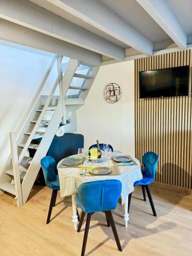 une salle à manger avec une table et des chaises bleues dans l'établissement L'escale du Mont, à Pontorson