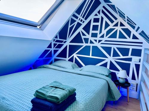 - une chambre dotée d'un lit avec un mur géométrique dans l'établissement L'escale du Mont, à Pontorson