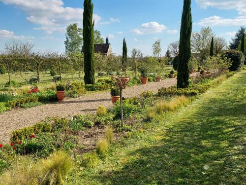 un jardin avec des fleurs et des plantes sur un chemin dans l'établissement Gîte 5 personnes dans une maison historique avec grand jardin, à Saint-Christophe-sur-le-Nais