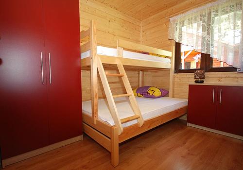 ein Schlafzimmer mit Etagenbetten in einer Holzhütte in der Unterkunft Domki Letniskowe Wydma in Bobolin