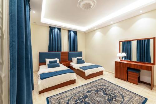 a bedroom with two beds and a piano at Almadinah Suite in Al Madinah