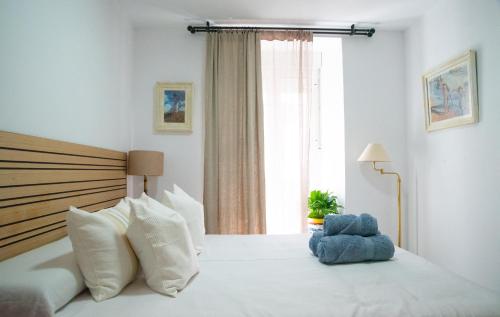 a bedroom with a white bed with a large window at Casa Hera - Boutique House in Alhaurín el Grande in Alhaurín el Grande