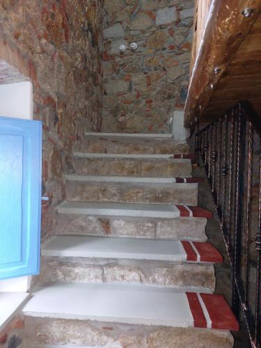 a set of stairs in a building with a stone wall at Su Furriadroxiu in San Vito