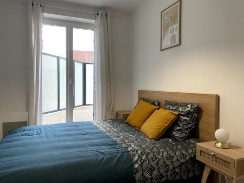 une chambre avec un lit bleu et une fenêtre dans l'établissement Modern apartment 10 min from Disneyland, à Coupvray
