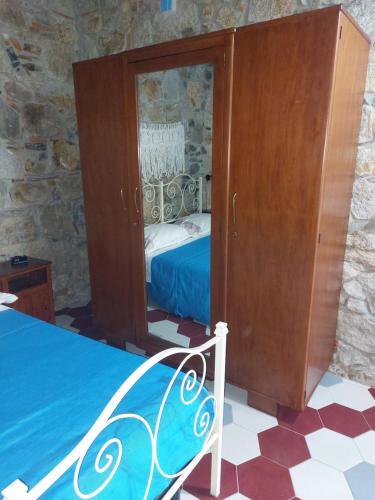 a bedroom with a bed and a wooden cabinet at Su Furriadroxiu in San Vito