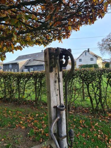 a metal hose hooked up to a wooden post at Haus Päsch near lake with heated jacuzzi sauna in Butgenbach