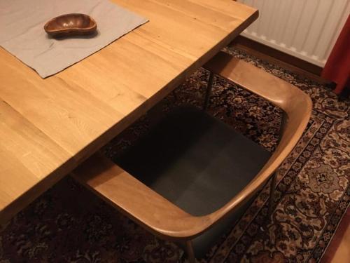 a wooden table with a chair next to a wooden table at Haus Päsch near lake with heated jacuzzi sauna in Butgenbach