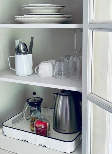 a pantry with dishes and utensils on a shelf at Athol Country Bed and Breakfast in Athol