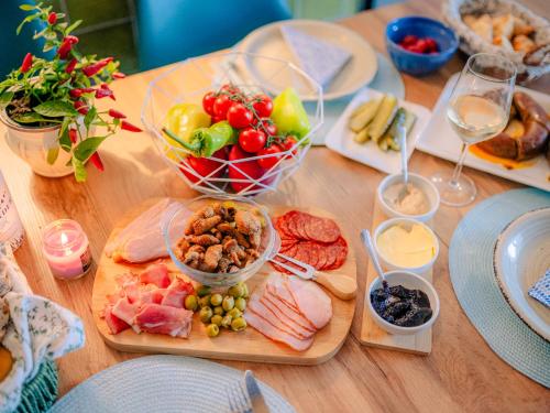 a wooden table with plates of food and glasses of wine at Kékbazalt Vendégház in Badacsonytomaj