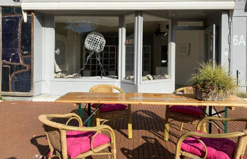 a wooden table and chairs in front of a store at B&B De Kunstpraktijk in Veldhoven