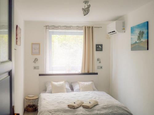 una camera da letto con un letto con due pantofole sopra di Kékbazalt Vendégház a Badacsonytomaj
