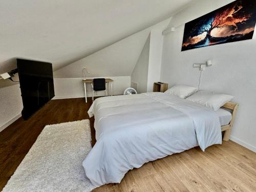 a bedroom with a large white bed with a painting on the wall at Cosy private room in Lausanne center in Lausanne