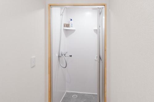 a shower with a glass door in a bathroom at Namba shiokusa in Osaka