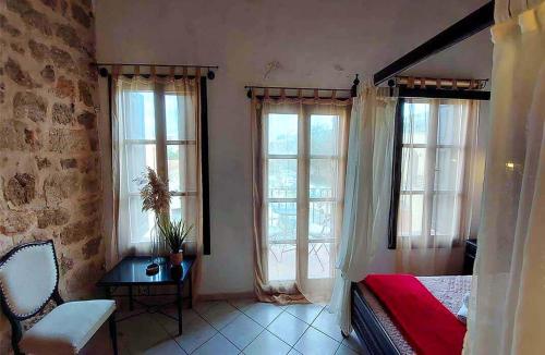 a bedroom with two windows and a bed and a chair at Saint Michel Hotel in Rhodes Town
