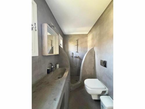 a bathroom with a toilet and a sink at White Rock Suites & Villas in Houlakia