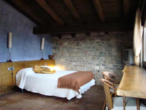 una camera con letto e parete in pietra di Monegal a Sant Llorenç de Morunys