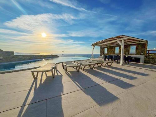 a group of benches sitting on a building overlooking the water at White Rock Suites & Villas in Houlakia