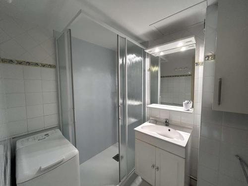 une salle de bain blanche avec une douche et un lavabo dans l'établissement Maison cosy proche plage avec jardinet et parking privé - 6 couchages, 2 chambres - FR-1-224-43, à Saint-Gilles-Croix-de-Vie