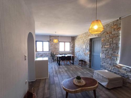 a living room with a table and a stone wall at Akallis Villa in Galini