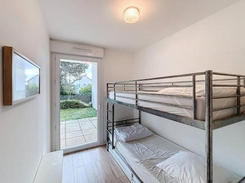 une chambre avec deux lits superposés et une fenêtre dans l'établissement Appartement rez-de-jardin, front de mer, 4 pers, calme, wifi gratuit - FR-1-465-46, à Merville-Franceville-Plage