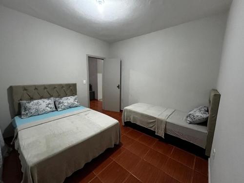 a bedroom with two beds in a room at Espaço Lara Eventos Igarapé in Igarapé