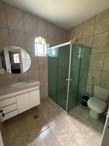 a bathroom with a shower and a sink and a toilet at Espaço Lara Eventos Igarapé in Igarapé