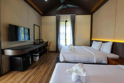 a hotel room with two beds with a stuffed animal on the beds at Momtikcamp Hotel in Ban Nong Muang