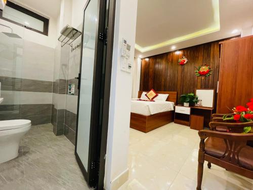 a bathroom with a bed and a shower and a toilet at SAPHIA Hotel Hue in Hue