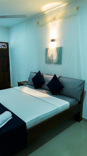 a bedroom with a large bed with a light on it at Dhanaya Safari Home in Udawalawe