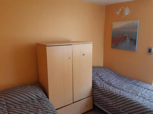 a small bedroom with a bed and a cabinet at Casa Escalera Caracol in Buenos Aires