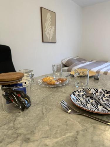 a table with plates and utensils on top at Charmant studio à 20min de Paris in Créteil