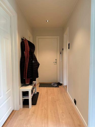 a hallway with a white door and a room with a wooden floor at Arctic Haven Apartment in Berlevåg