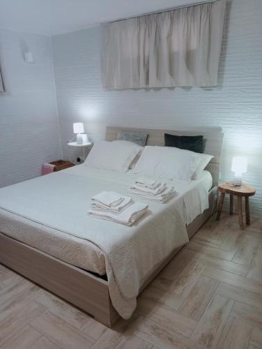 a bedroom with a bed with white sheets and a window at L'alloggio delle vacanze estive in Corsano