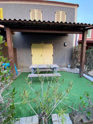 a picnic table in front of a house with a yellow door at Belle marina en bord d'étang in Le Barcarès