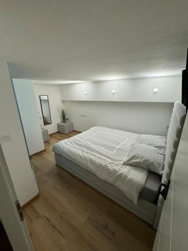 une chambre avec un grand lit et un parquet dans l'établissement Duplex Place du Théâtre Dijon Centre, à Dijon