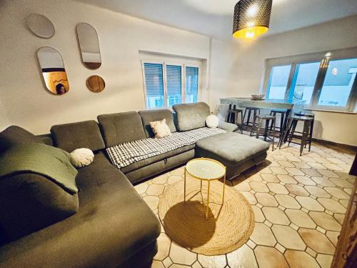 un salon avec un canapé et une table dans l'établissement Chez Mamie Wifi Un Séjour à Part, à Moyeuvre-Grande