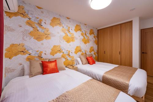 a bedroom with two beds and a floral wall at Great Fuji Kawaguchiko in Fujikawaguchiko