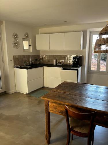 une cuisine avec une table en bois et une salle à manger dans l'établissement Jolie maison de village, à Bormes-les-Mimosas