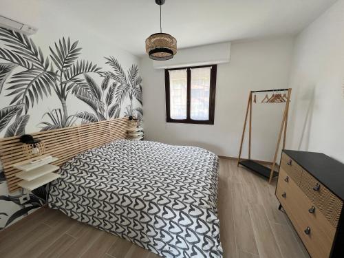 une chambre avec un lit avec une fresque végétale sur le mur dans l'établissement Havre de Livia, cosy T2 meuble proche plage, à Six-Fours-les-Plages