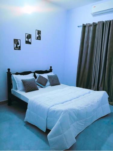 a bedroom with a large bed with a blue wall at Private 3BHK Villa with Indoor Pool in Tirupporūr