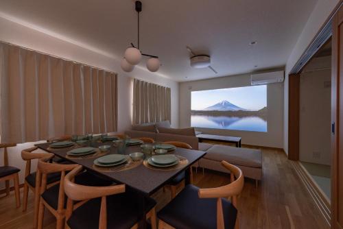 a living room with a dining room table with a view of a mountain at Great Fuji Kawaguchiko in Fujikawaguchiko