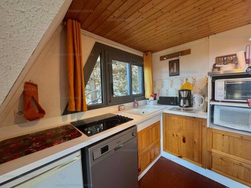 una piccola cucina con lavello e microonde di Chalet 6 couchages avec balcon et parking aux Angles - FR-1-295-170 a Les Angles
