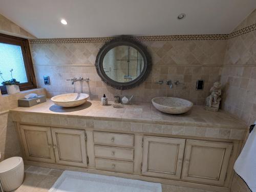 a bathroom with two sinks and a large mirror at Moulin Rouhaud in Montboyer