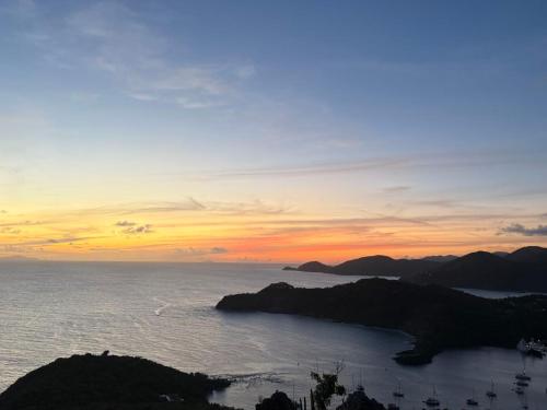 a sunset over the ocean with islands in the water at Luxury Waterfront Villa 431 F in Jolly Harbour