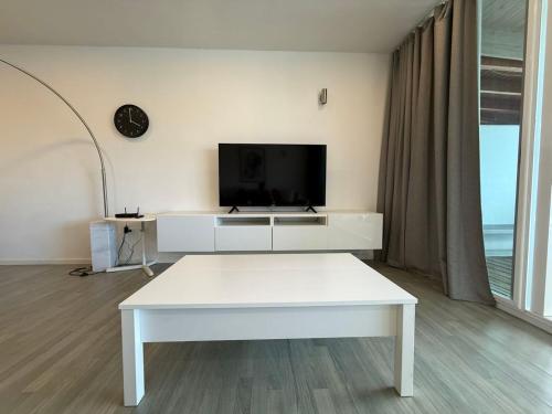 a living room with a white table and a tv at Luxury Waterfront Villa 431 F in Jolly Harbour