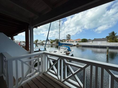 a balcony with a boat in the water at Luxury Waterfront Villa 431 F in Jolly Harbour