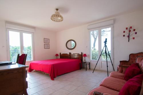 - une chambre avec un lit rouge et une caméra dans l'établissement 83sygu, à Lorgues