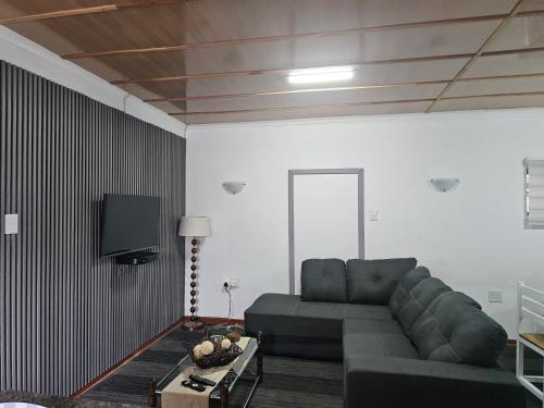 a living room with a couch and a tv at The Haven: Make our Home your Home in Estcourt