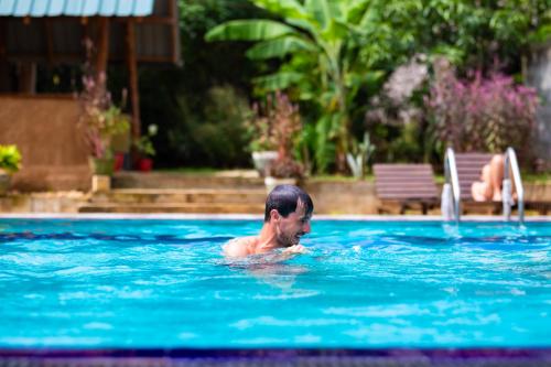 a man swimming in a swimming pool at Maika safari lodge in Udawalawe